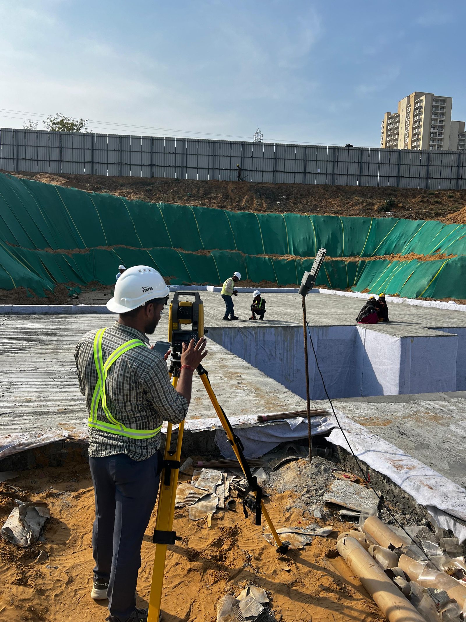 Surveyor setting out with a total station on a completed raft slab