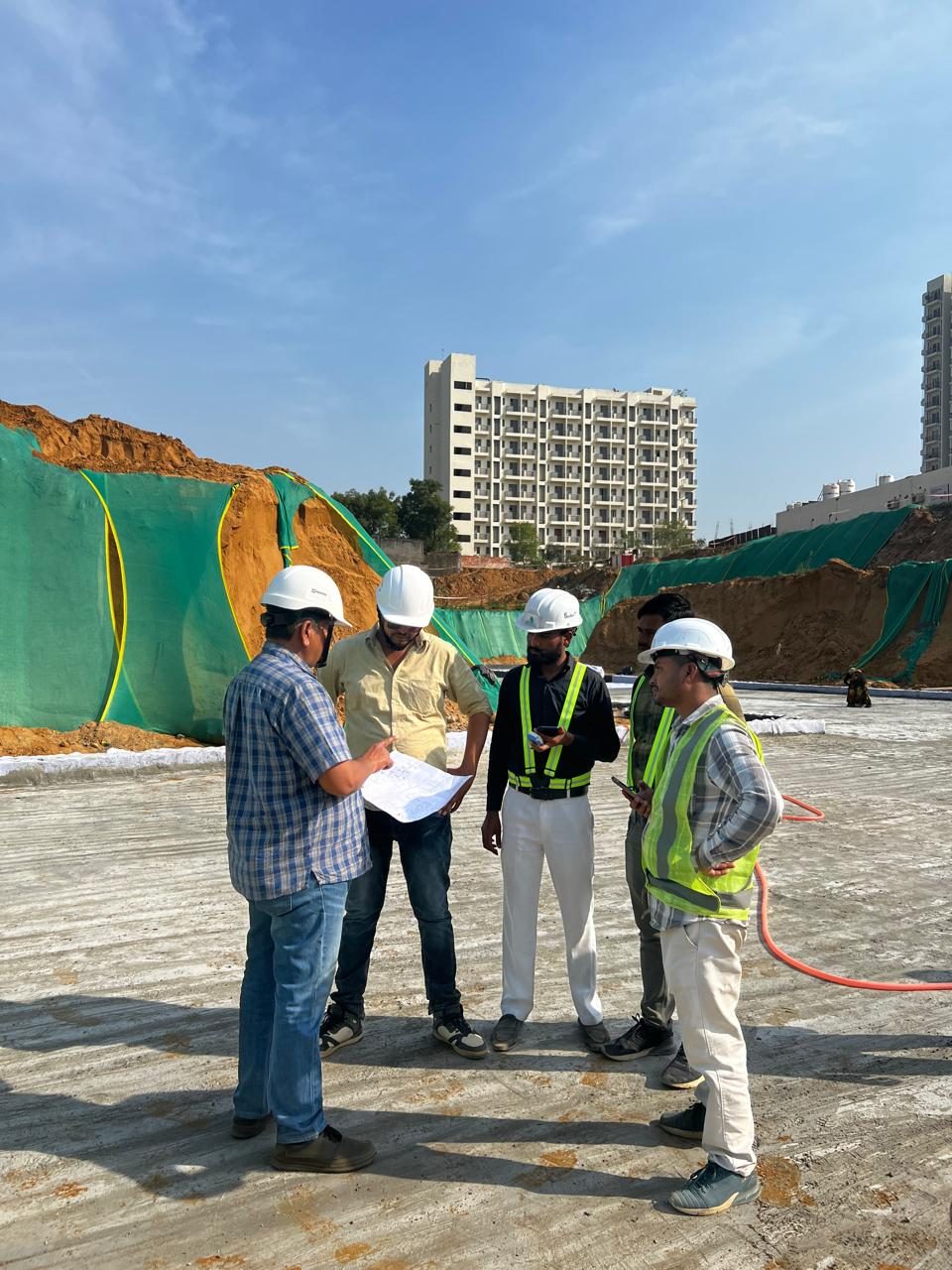 Site team reviewing drawings together on a cast slab